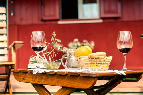 a table with two glasses of wine and a basket of food at Villa Irene Pisticci-Matera in Pisticci