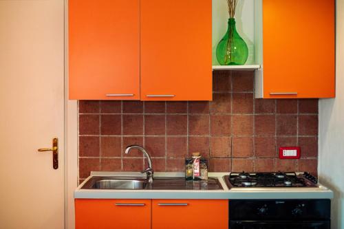 a kitchen with orange cabinets and a sink at Villa Irene Pisticci-Matera in Pisticci