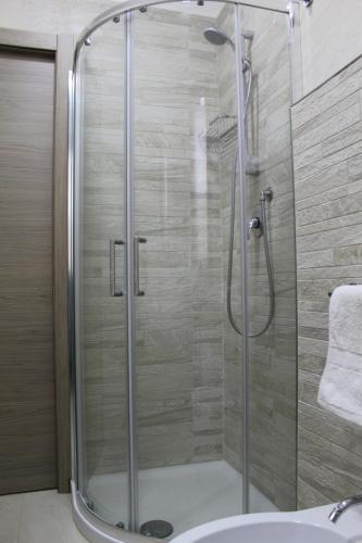 La salle de bains est pourvue d'une douche avec une porte en verre. dans l'établissement A&G Casa Vacanze Naxos-Taormina, à Giardini Naxos