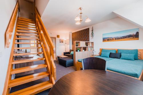 a living room with a staircase leading to a bedroom at Skiapartma - Říčky v Orlických horách in Říčky