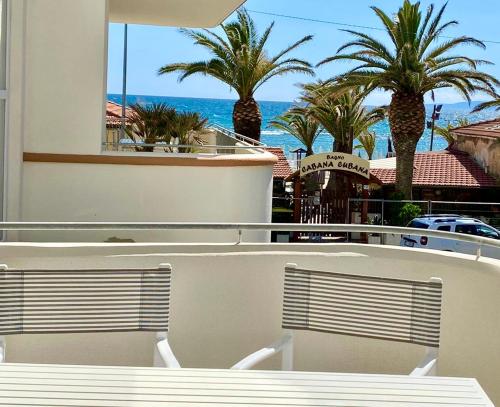 a balcony with a view of the ocean and palm trees at Via Firenze 11 in Follonica
