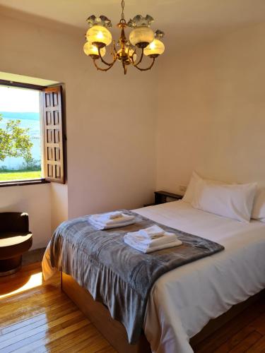 a bedroom with a bed with two towels on it at Chalet do Médico in Rodeiro