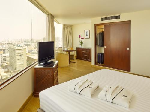 
a hotel room with two beds and a television at Hotel Estelar Miraflores in Lima
