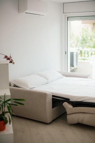 a white bed in a room with a window at Dalex in Salou