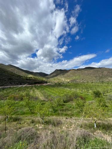 pole z zieloną trawą i wzgórzami pod pochmurnym niebem w obiekcie Luby Cortijo El Horno w mieście Lubrín