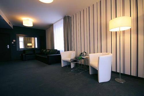 a room with a table and chairs and a couch at Hotel Grafit in Kielce