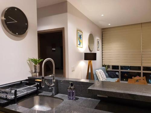 a kitchen with a sink and a clock on the wall at Orange & Green Apartment - HP Sur in Mexico City