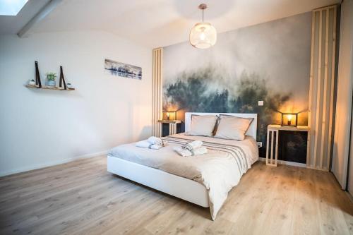 a bedroom with a bed with two lamps on it at Appt Ambiance Chalet 2ch Piscine lagon in Tarbes