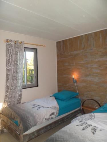 une chambre avec deux lits jumeaux et une fenêtre dans l'établissement l'atelier des reves, à Écuras