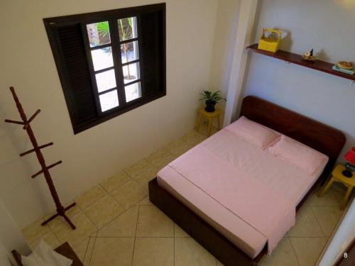 a small bedroom with a bed and a window at Casa à Beira-Mar com Churrasqueira, TV e Wi-fi in Balneário Praia do Leste