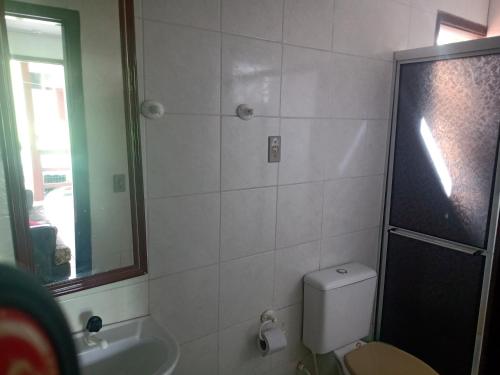 La salle de bains est pourvue de toilettes, d'un lavabo et d'un miroir. dans l'établissement Mare Mar, à Tramandaí