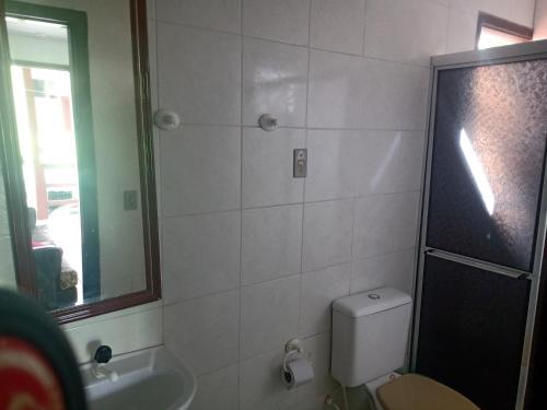 a bathroom with a toilet and a sink and a mirror at Mare Mar in Tramandaí