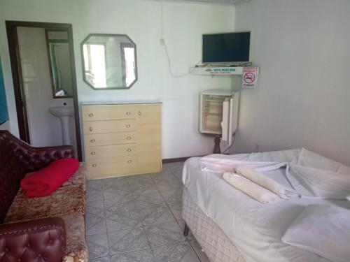 1 dormitorio con 1 cama, 1 silla y TV en Mare Mar, en Tramandaí