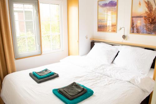 a bedroom with a bed with two towels on it at Chalet 't zeeuwse genot in Baarland