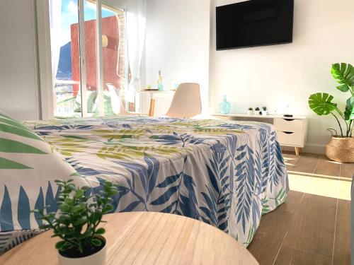 una camera con un letto con una coperta blu e bianca di BENALMADENA BOLBORETA STUDIO a Benalmádena
