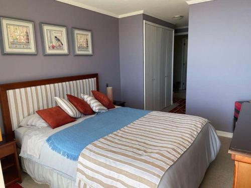 a bedroom with a bed with red and white pillows at Amplio y hermoso departamento frente al mar in Puchuncaví