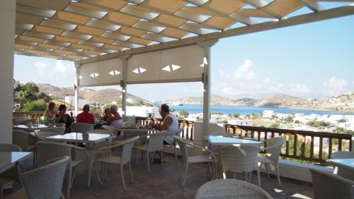 people sitting at tables in a restaurant at Homer's Inn Hotel in Ios Chora
