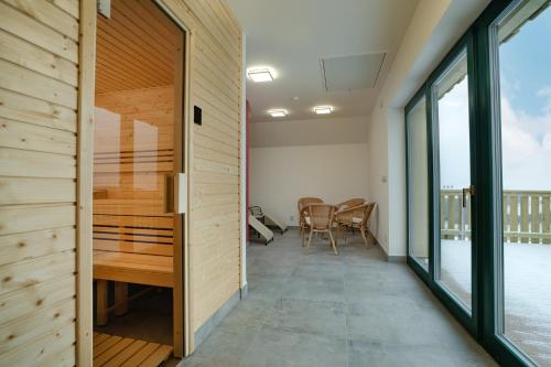 a room with a wooden door and a table and chairs at Penzion U Černého kohoutka in Zdíkov