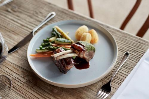 a plate of food with meat and vegetables on a table at Accommodation @ Curlewis in Curlewis