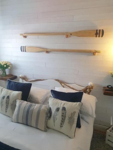 un letto bianco con cuscini sopra di Boutique Coastal appt nr Edinburgh a Saint Davids