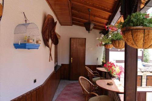 restauracja ze stołami i krzesłami oraz klatką dla ptaków w obiekcie Hostel Bushati w mieście Prizren