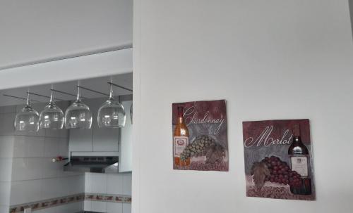 una cocina con dos fotos de botellas de vino en Girardot Resort Ap 6-402 Exclusiva vista panorámica-wi-fi, en Girardot