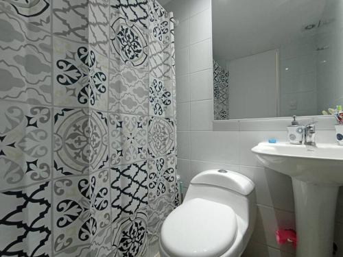 un bagno con un water bianco e un lavandino di Hermoso Dpto entre bosque y piscina. a El Tabo