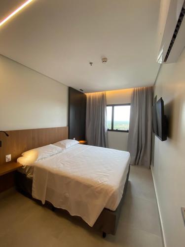 a bedroom with a large bed and a window at Salinas GAV Resorts in Salinópolis