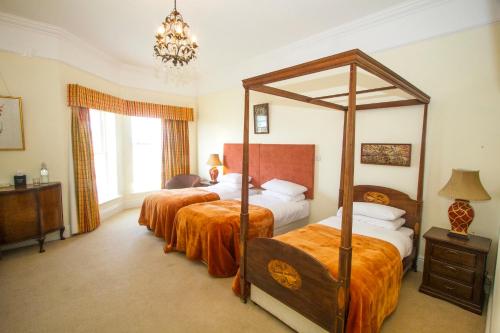a bedroom with two beds and a canopy bed at Emlagh House in Dingle