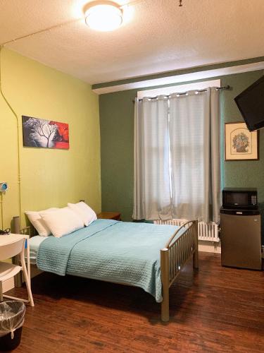 a bedroom with a bed and a television in it at Orange Village Hostel in San Francisco