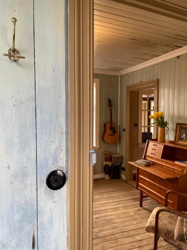 a room with a piano and a room with a guitar at The Old Bookstore in Flateyri