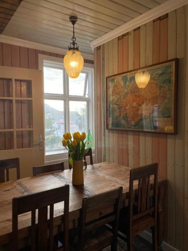 a dining room table with a vase of flowers on it at The Old Bookstore in Flateyri