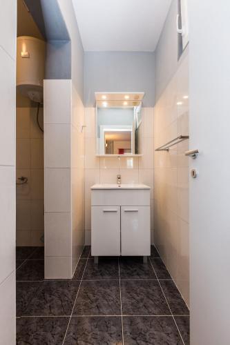 a bathroom with a white sink and a mirror at Apartments Lemmy in Zadar