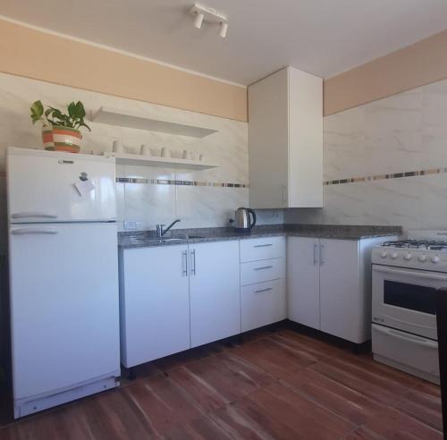 a kitchen with white cabinets and a white refrigerator at Finca La Calma in San Rafael