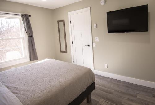um quarto com uma cama e uma televisão de ecrã plano em The Overlook at Burdett Falls em Burdett