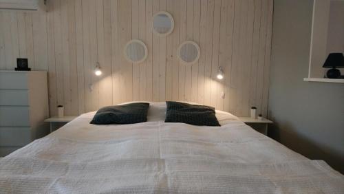 Un dormitorio con una gran cama blanca con dos almohadas. en Gäststuga i centrala Ystad, en Ystad