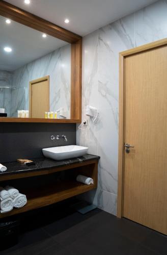 a bathroom with a sink and a mirror at Grand Opera Hotel in Kutaisi