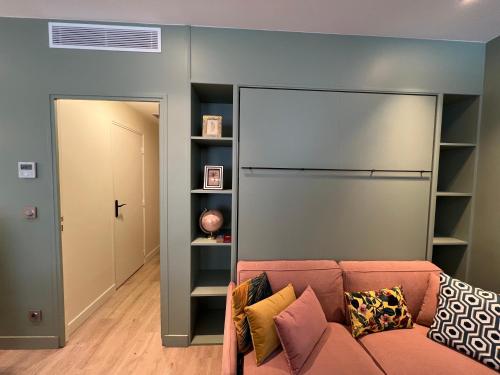 - un salon avec un canapé et un mur avec des étagères dans l'établissement Relais Cocorico 2 Bedrooms with AC, 2 bathrooms, 8 min Eiffel Tower, à Paris