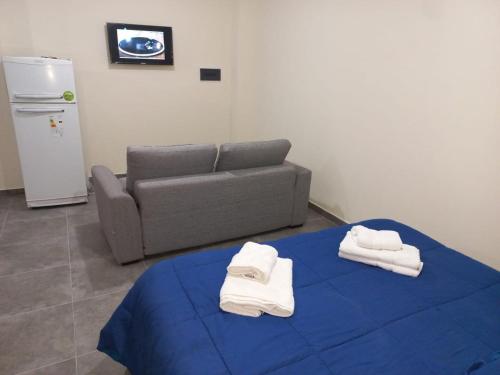 sala de estar con sofá y mesa con toallas. en Altos la Villa, en San Rafael