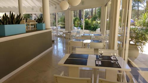 un ristorante con tavoli e sedie bianchi e piante di Green Park 2 Ambientes en PB con Jardín y Parrillero a Punta del Este