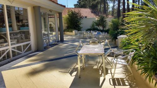 una fila di tavoli e sedie su un patio di Green Park 2 Ambientes en PB con Jardín y Parrillero a Punta del Este