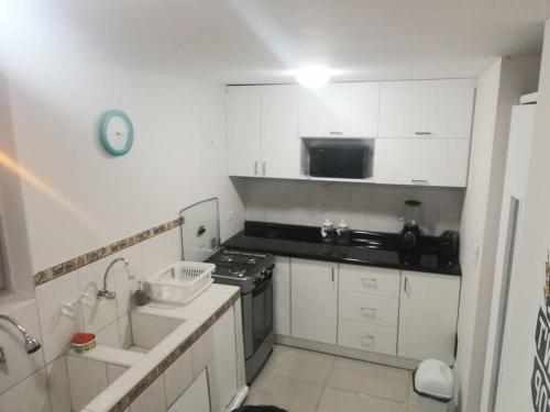 a kitchen with white cabinets and a stove top oven at Jacky's Home Santa Rosa in Lima