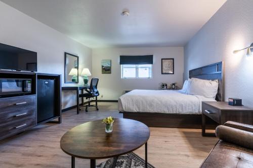 a hotel room with a bed and a table at The Scout INN in Cody