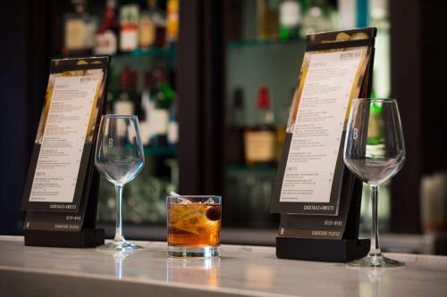 a table with two wine glasses and a drink at Sonesta Select Phoenix Camelback in Phoenix