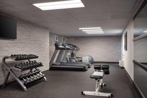 a gym with several treadmills and weights in a room at Sonesta Select Phoenix Camelback in Phoenix