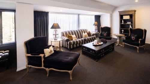 a living room with a couch and chairs and a table at Hotel Montreal in Christchurch