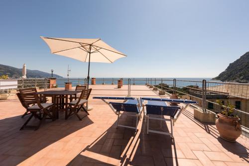 a patio with a table and chairs and an umbrella at Poseidon Apartment 011019-LT-0180 in Monterosso al Mare