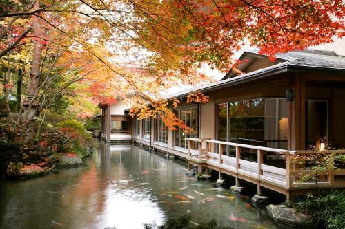 a house with a river in front of a building at Suimeikan in Gero