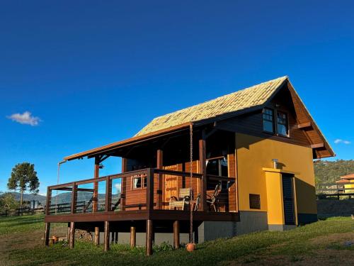 a house with a large deck on a hill at Chão de Estrelas Cabanas in Urubici