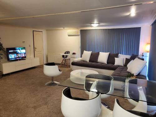 a living room with a couch and a tv at Deluxe Holiday Home in Putten